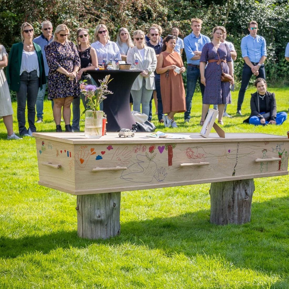 Een kist die door kinderen is beschilderd, opgebaard in de tuin